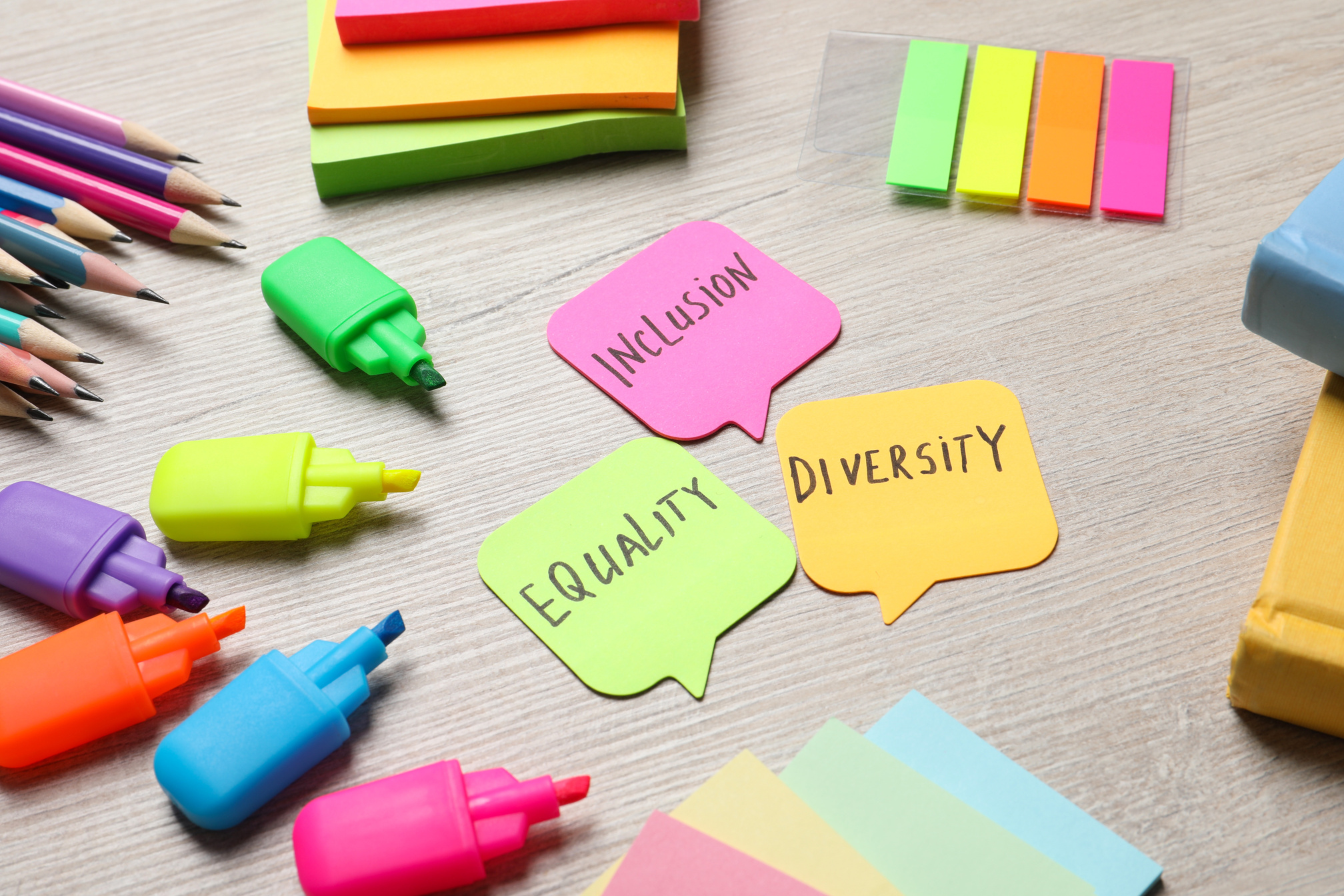 Sticky Notes with Words Diversity, Equality, Inclusion and Stationery on Wooden Table