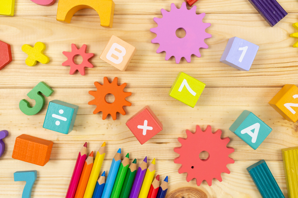 Colorful math fractions, cubes, pencils on wooden table. Interesting mathematics for kids. Education, back to school concept